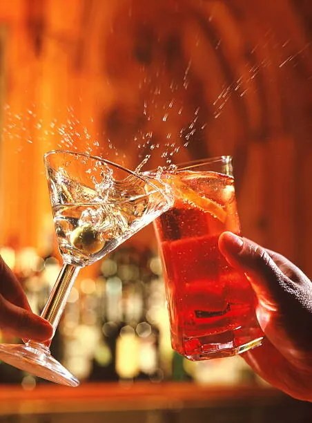 Foto Couple clinking glasses, spilling drink, close-up, Peter Dazeley