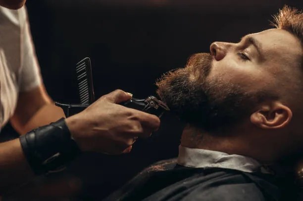 Foto Young bearded man getting beard haircut, zamrznutitonovi