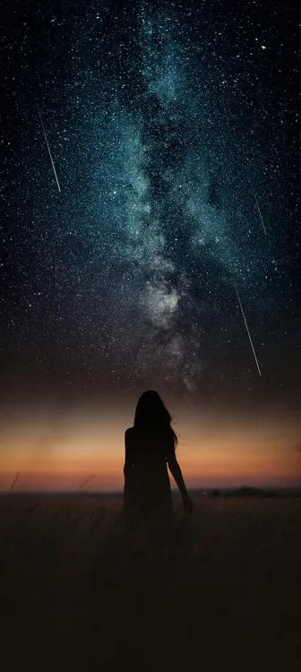 Fotobehang Dramatic and fantasy scene with young woman looking universe with falling stars., (22.4 x 50 cm)